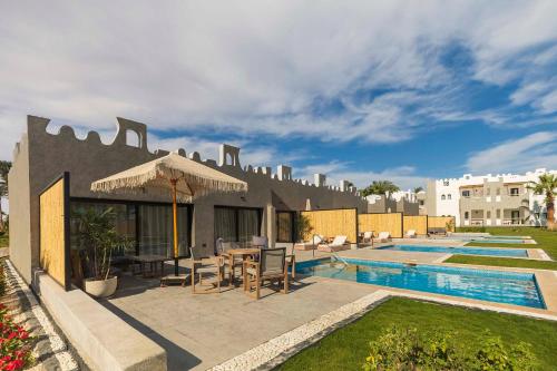 a villa with a swimming pool and a resort at Sunrise Tucana Resort Grand Select in Hurghada
