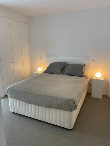 a bedroom with a large bed with two lamps at Fuzeta stylish 1 bedroom apartment - Amazing views in Fuzeta