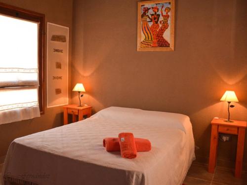 a bedroom with a white bed with two lamps at Cabañas Villa del Sol in Salta
