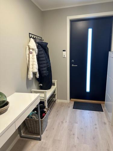 a room with a blue door and a shelf with shoes at Lofoten Kabelvåg-small apartment in Kabelvåg