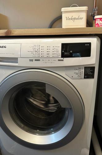 a washing machine with a wooden shelf on top of it at Lofoten Kabelvåg-small apartment in Kabelvåg