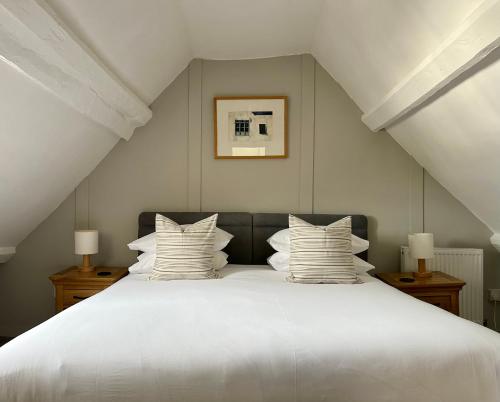 a bedroom with a large white bed with pillows at Number 22, Castle Street in Hay-on-Wye