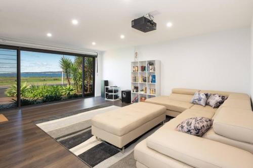 ein Wohnzimmer mit 2 Sofas und einem großen Fenster in der Unterkunft Absolute Waterfront, Amazing Views, Maloneys Beach in Maloney's Beach