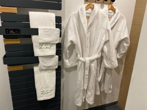 baño con toallas colgadas en la pared en La Suite Chambre d’hôtes Spa et Sauna, en Aire-sur-la-Lys