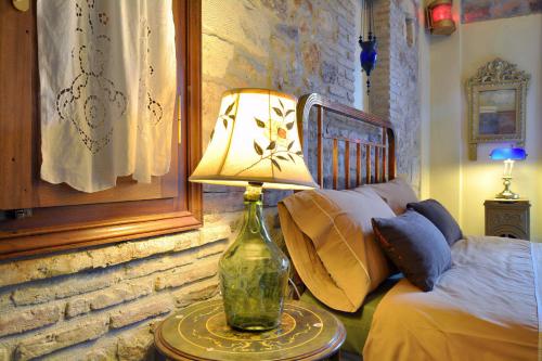 a lamp on a table in a bedroom with a bed at Archontiko Art Hotel in Galaxidhion