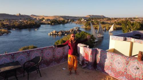 a man standing on a wall next to a river at Go Inn Backpackers in Aswan