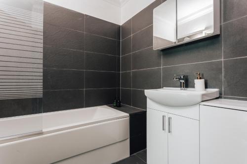 a bathroom with a white sink and a bath tub at Spacious 2 bedroom flat near beach and town centre in Bournemouth