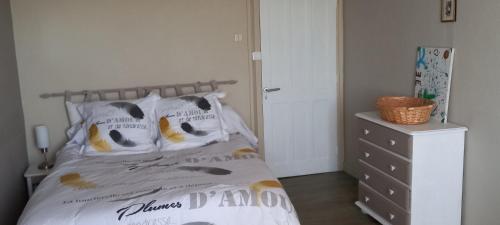 Schlafzimmer mit einem Bett mit weißer Bettwäsche und Kissen in der Unterkunft Chez Zabou in Rosières