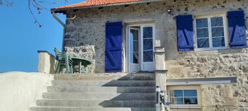 ein Steinhaus mit blauen Fensterläden und Treppen in der Unterkunft Chez Zabou in Rosières