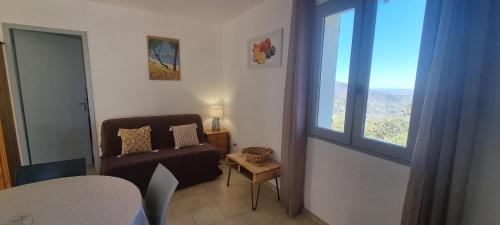 un salon avec un canapé et une fenêtre dans l'établissement Vos vacances à Lama France Corse, à Lama