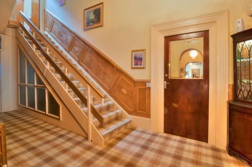 a staircase in a home with a wooden door at The Purple Tree Guest House in Torquay