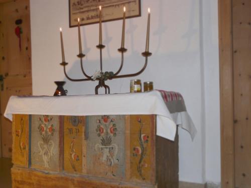 a table with a white table cloth and candles on it at B & B Apartments Ortlerblick in Sluderno