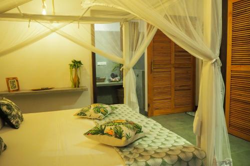 a bedroom with a canopy bed with two pillows on it at Temple House Villa in Hikkaduwa