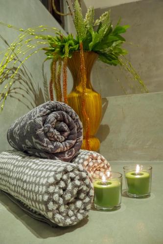 a table with two candles and towels and a vase at Temple House Villa in Hikkaduwa