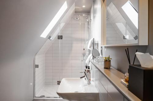 a white bathroom with a sink and a shower at The Ginger Pig in Brighton & Hove