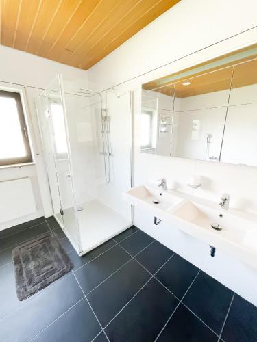 een witte badkamer met 2 wastafels en een douche bij Ferienwohnung Balu in Kronau