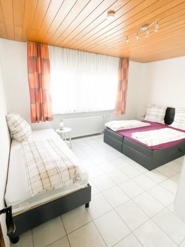 een slaapkamer met 2 bedden en een raam bij Ferienwohnung Balu in Kronau