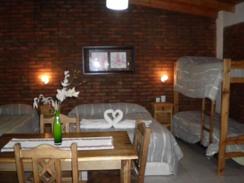 um quarto com duas camas e uma mesa e cadeiras em Posada de campo Mamúll Mapú em Rancul