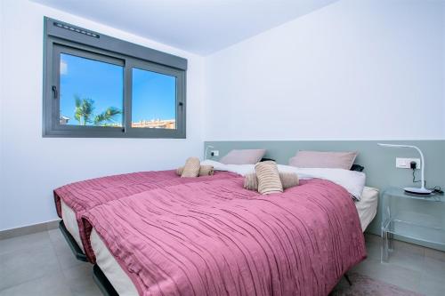 a bedroom with a large bed with a pink blanket at Prime Spanish Holidays - Arenal Dream in Jávea