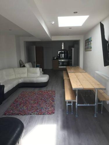 a living room with a couch and a wooden table at Myrtle villa 10 bedrooms sleeps 28, 2 min to beach in Weymouth