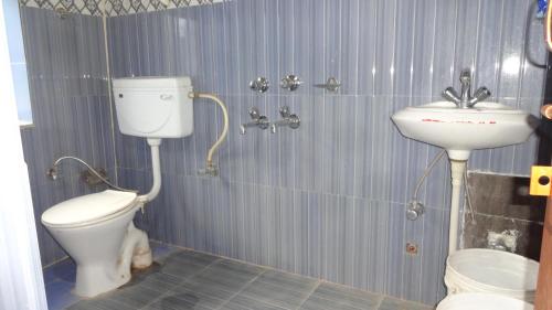 y baño con aseo y lavamanos. en Nizer khangchung Homestay, en Mani
