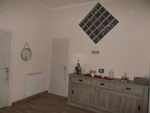 a room with a dresser and a clock on the wall at Alba Ionica Taranto in Taranto