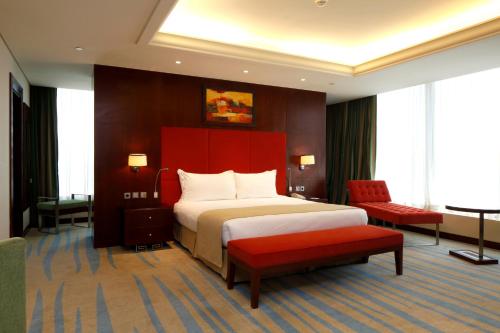 a hotel room with a bed and a red headboard at Holiday Inn Olaya by IHG in Riyadh