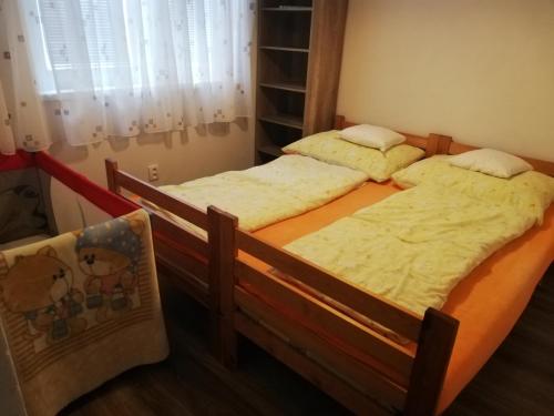 two twin beds in a room with a window at TOBO house along the river Danube in Radvaň nad Dunajom