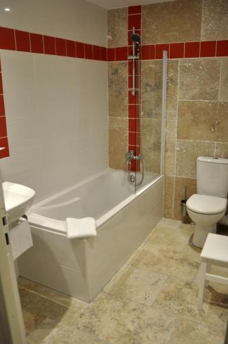 a bathroom with a white tub and a toilet at Le Clos d'Orange - Hotel & ville de Provence in Orange