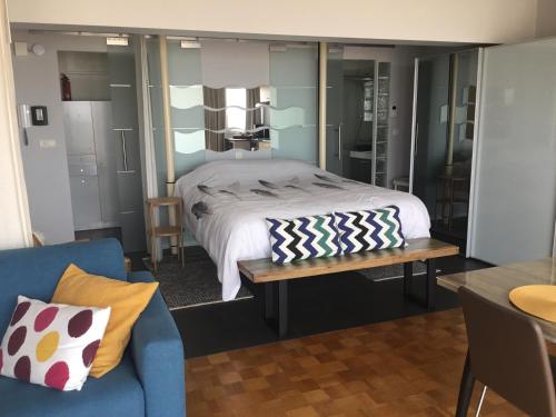 - une chambre avec un lit et un canapé bleu dans l'établissement Royal Zeezicht Oostende, à Ostende