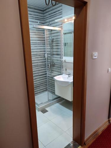 a bathroom with a glass shower and a sink at Premier Hotel in Skopje