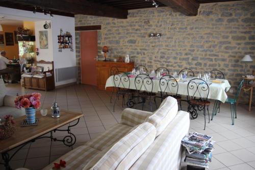 Il comprend un salon avec une table et des chaises. dans l'établissement Au Rendez vous de l'Auxois B&B, à Essey