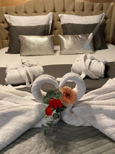 ein Bett mit zwei Schwänen Handtüchern und Blumen darauf in der Unterkunft Le Nid d'Ange in Ohey