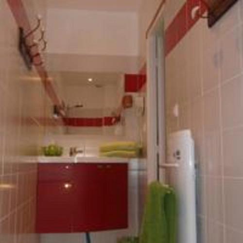 La salle de bains est pourvue d'un évier et d'un réfrigérateur rouge. dans l'établissement Au Rendez vous de l'Auxois B&B, à Essey