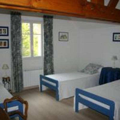 Cette chambre comprend 2 lits, une fenêtre et une porte. dans l'établissement Au Rendez vous de l'Auxois B&B, à Essey