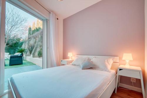 a bedroom with a white bed and a large window at Le 002 - T3 climatisé avec terrasse in Marseille