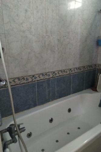 een badkamer met een bad met blauwe tegels bij Chambre 5 minutes de la gare à pieds in Les Mureaux