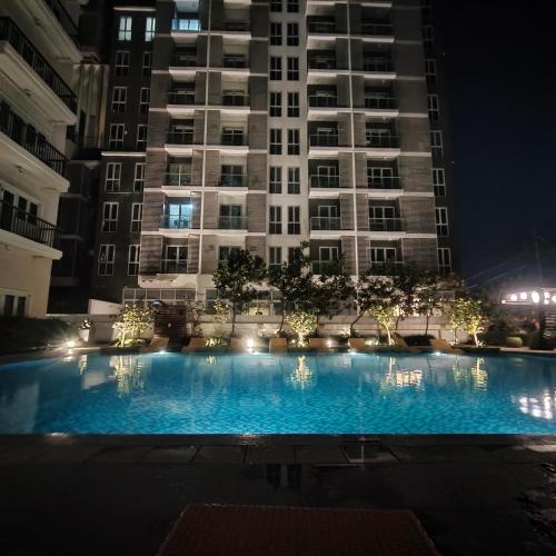een groot zwembad voor een gebouw 's nachts bij Lafayette Park Square Iloilo in Iloilo City