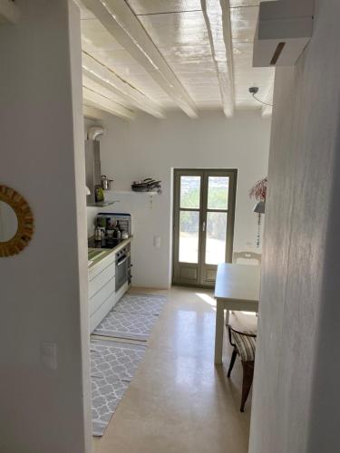 cocina con paredes blancas, mesa y barra en Amorgos Villa Handras / Main villa, en Amorgós