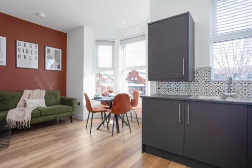 a kitchen and living room with a table and a couch at Eastside Capital Apartments in Belfast