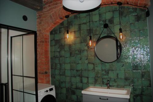 a bathroom with a sink and a mirror at Apartamenty STARA PIEKARNIA in Płock