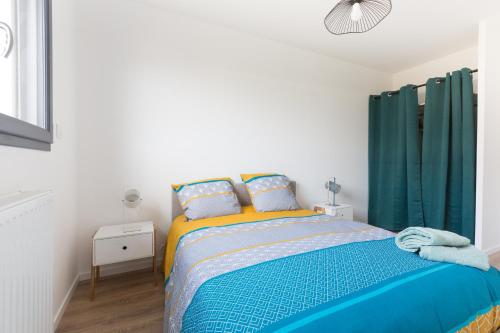 a bedroom with a bed and green curtains at Sea house with Jaccuzy in Bretteville-sur-Ay