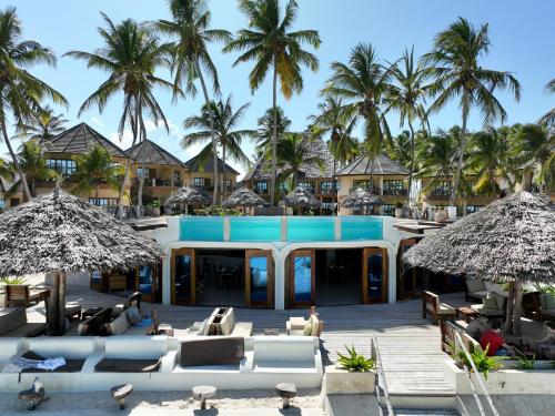 un complejo con piscina y palmeras en Zula Zanzibar, en Paje