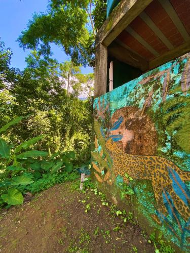 a wall with a painting of a leopard on it at Greensoul Hospedagem in Ubatuba