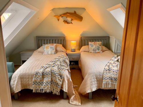 two beds in a attic room with a roof at Romantic luxury Cottage right next to the ocean in Saint Abbs