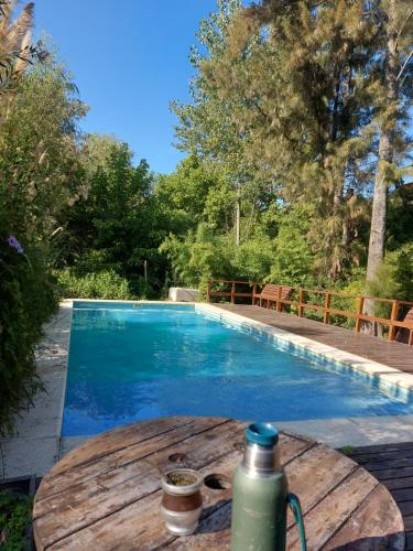 a table with a water bottle on a table next to a swimming pool at Cabañas Amo Río - Delta in Tigre