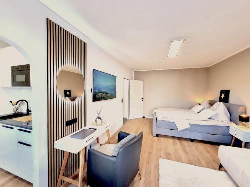 Habitación con cama, escritorio y cocina. en BaMo Studio - modern living lakeside en Klagenfurt