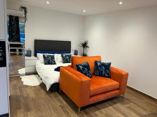 a bedroom with an orange chair and a bed at Cosy Detached Annexe With Free Off Street Parking in Milton Keynes