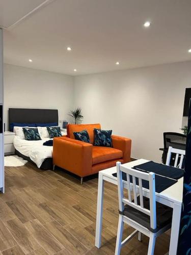 a living room with a couch and a table at Cosy Detached Annexe With Free Off Street Parking in Milton Keynes