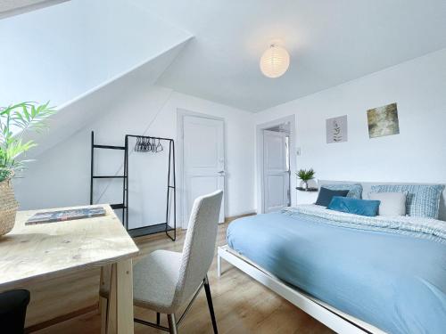 1 dormitorio con 1 cama azul, mesa y silla en 2 appartement entier 3 pièces, 2 chambres, idéal famille et travail, parking gratuit, en Mulhouse